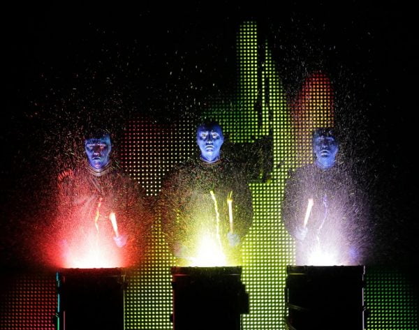 Blue Man Group Universal Orlando: image of three blue men hitting drums that glow with paint