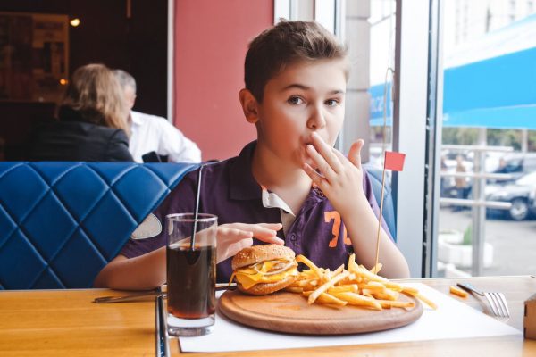 Restaurants where kids eat free in Orlando: image of kid eating a cheap meal