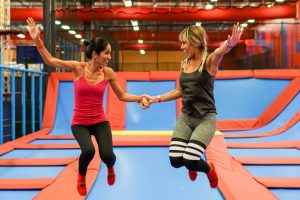 Cheap things to do with kids Orlando: image of two women jumping on trampolines at Planet Obstacle in Lake Mary