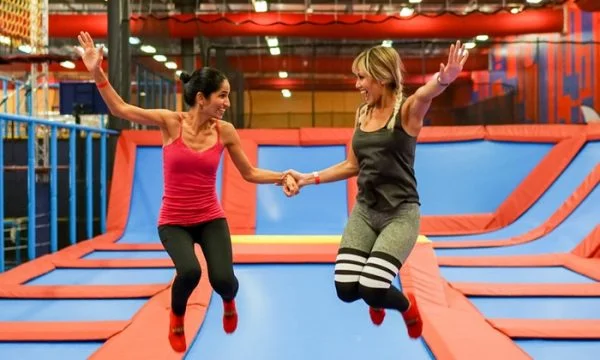 Cheap things to do with kids Orlando: image of two women jumping on trampolines at Planet Obstacle in Lake Mary