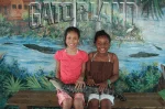 Gatorland Orlando deals: image of two girls holding a baby alligator at Gatorland Orlando theme park