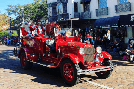 Holiday events Orlando: image of Santa and Mrs. Claus riding on a fire truck during the Annual Winter Park “Ye Olde Hometown” Christmas Parade
