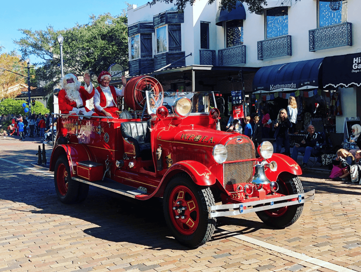 Holiday events Orlando: image of Santa and Mrs. Claus riding on a fire truck during the Annual Winter Park “Ye Olde Hometown” Christmas Parade