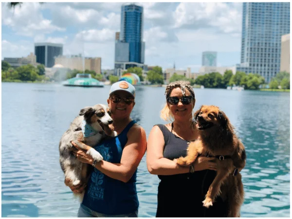 Dog parks in Orlando: image of two people hanging out with their dogs near Lake Eola Park in downtown Orlando, a dog-friendly spot to walk and play