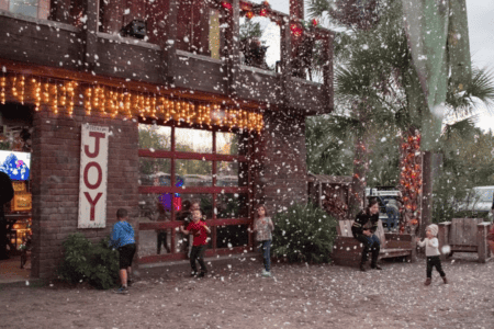 Holiday events and things to do for Christmas in Orlando: image of kids playing in Florida "snow" outside at Wekiva Island's Winter Wonderland event in Longwood, FL.